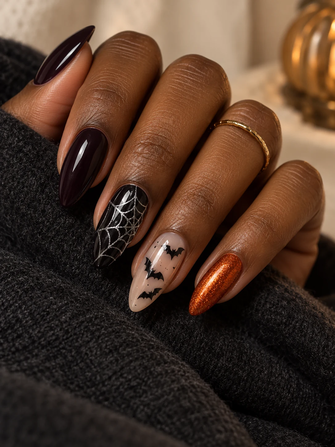 Plum-black almond nails with silver spiderwebs, black bats and copper sparkle