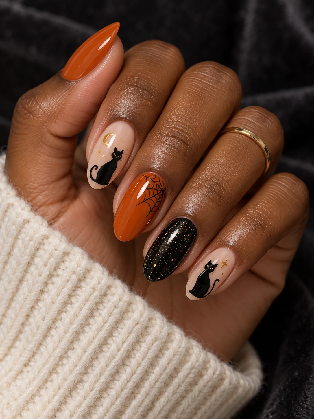 Orange, nude and black shimmer nails with black cats, gold details and a spiderweb