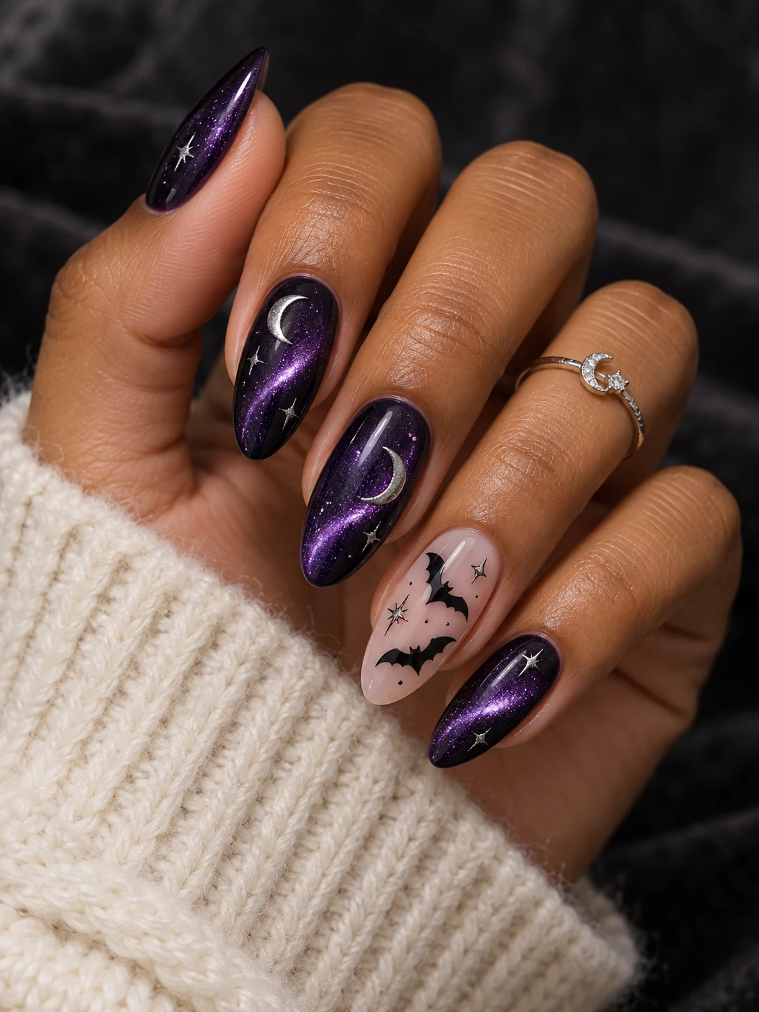 Purple cat-eye almond nails with silver crescent moons, stars and black bats